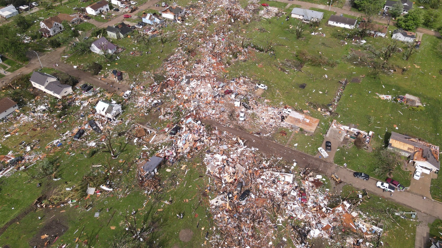 Aerial drone storm damage photo showing a long debris path through homes and yards